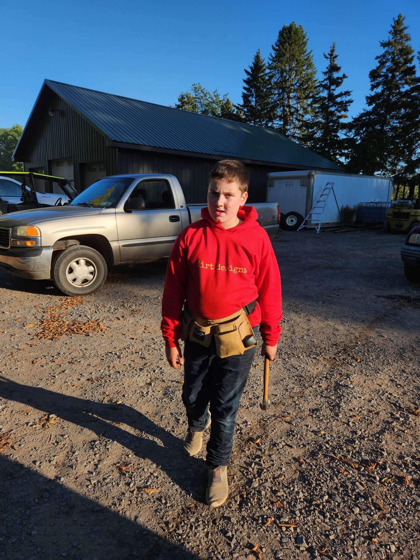 Casen with a tool belt at the shop, ready to fix apple bins