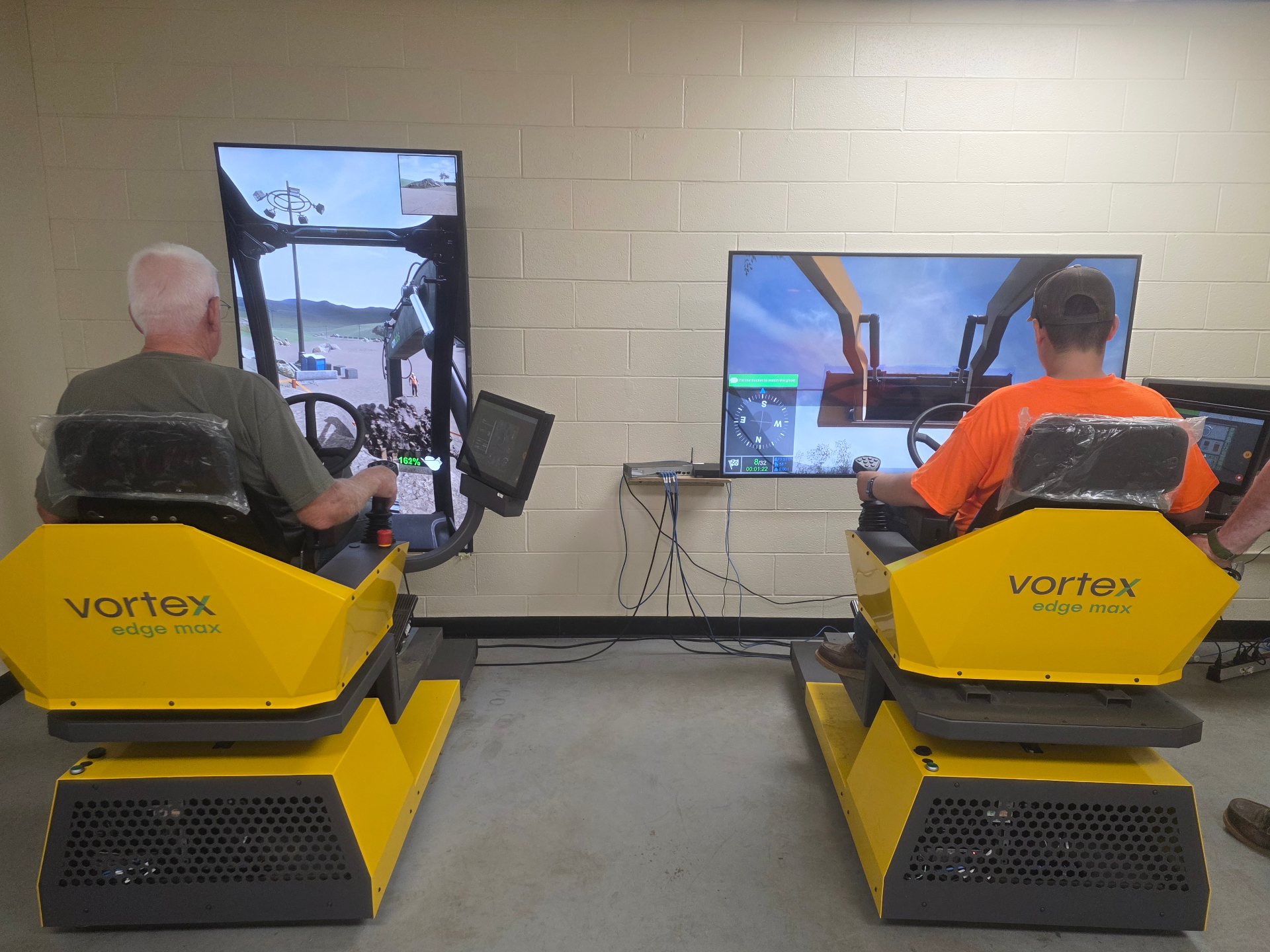 Casen and Grandpa Jim using heavy equipment simulators.