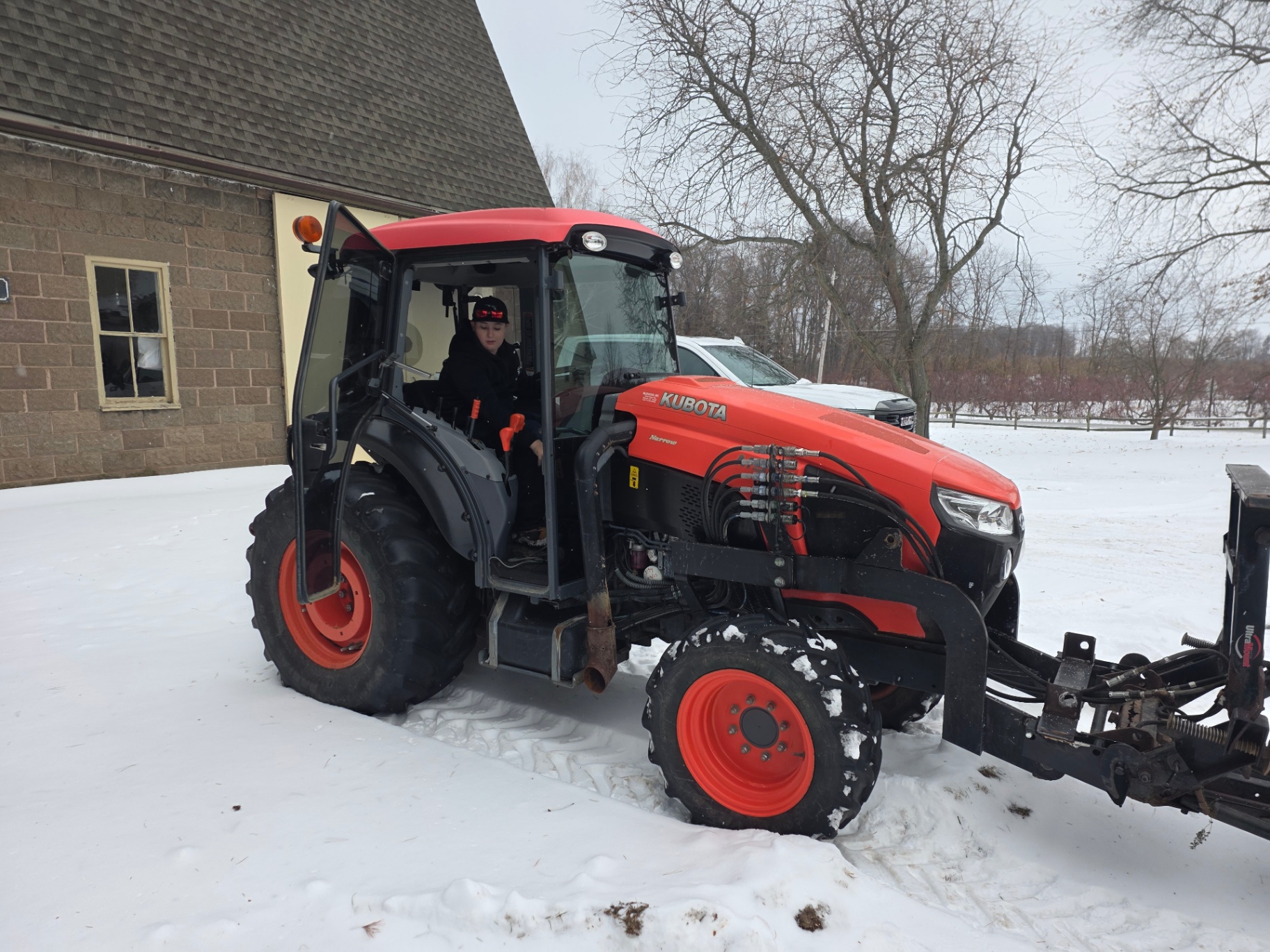 Casen driving the Kubota with a snow plow attached