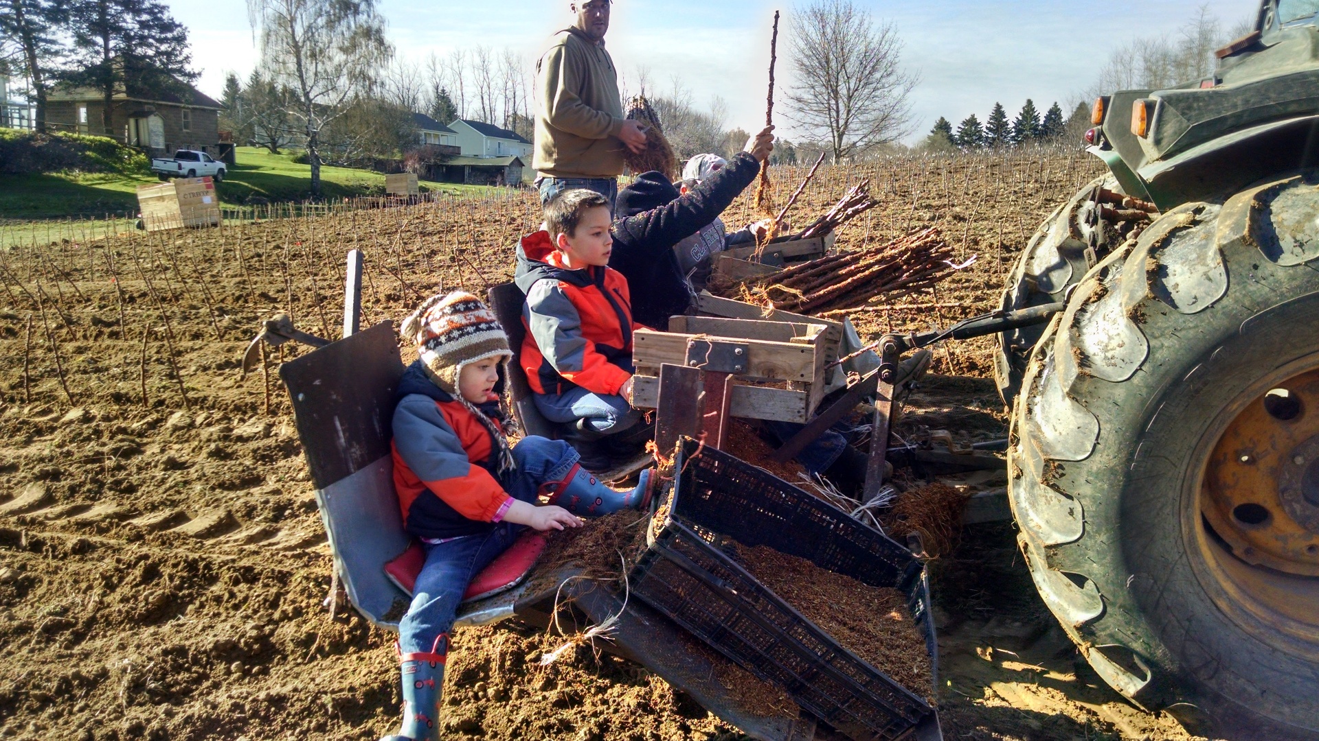 Carter and Casen riding along on the tree planter
