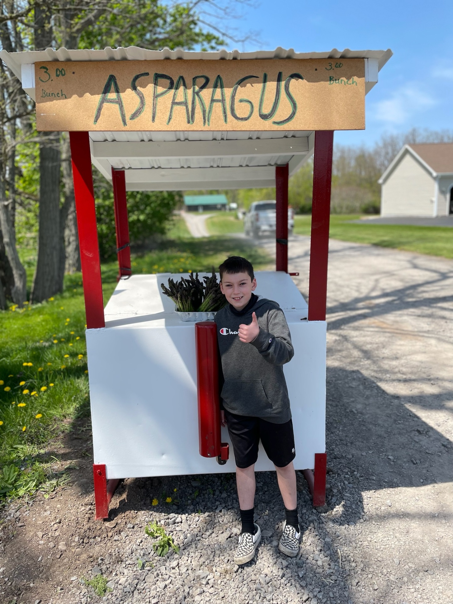 Carter standing next to his roadside asparagus stand